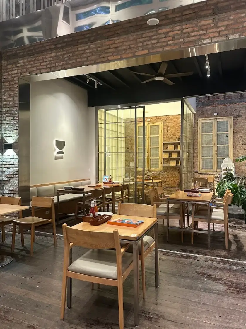 Bên trong Union Pizza với tường gạch trần, dầm thép và bàn ghế gỗ sồi